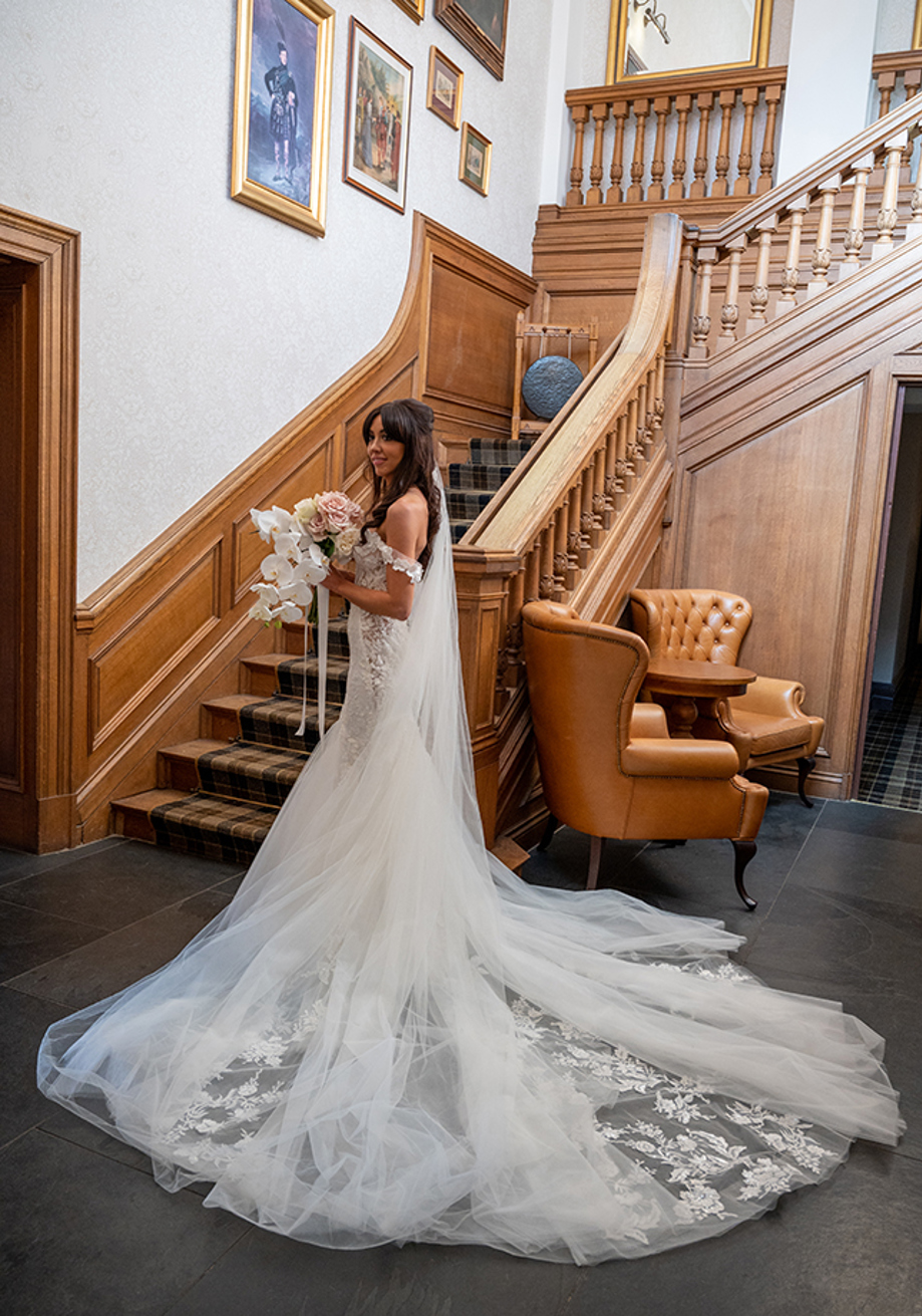 Bride poses at bottom of stairs before ceremony